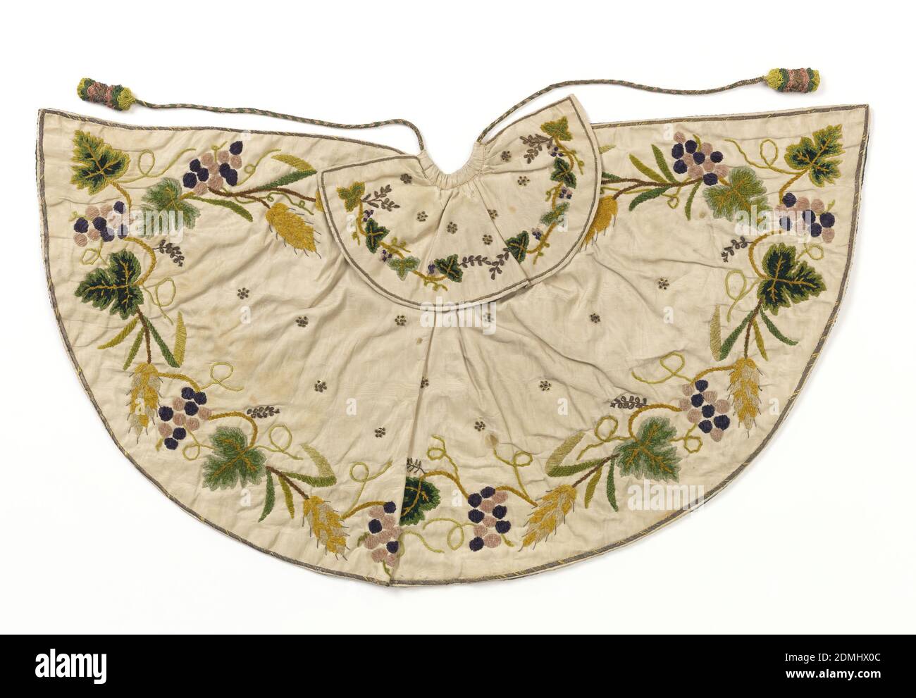 Cape pour une figurine ecclésiastique, moyenne: Soie, fils métalliques, paillettes technique: Brodée avec chenille et fils métalliques sur la moire, petite cape pour une figure ecclésiastique, le 'Bambino'. Moire de soie blanche brodée avec chenille de soie dans les verts, jaunes, violets, et paillettes et fil d'or. Dessin de vigne et de blé, à grande échelle, autour du cap et sur le col., France, 1750–99, costume et accessoires, Cape pour une figurine ecclésiastique Banque D'Images