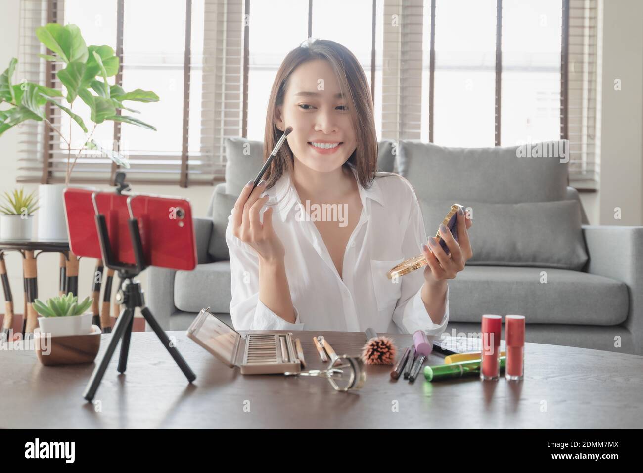 Jeune femme influenceur de beauté faisant un tutoriel vidéo pour elle salon de beauté sur les cosmétiques pendant votre séjour à la maison en toute sécurité Banque D'Images