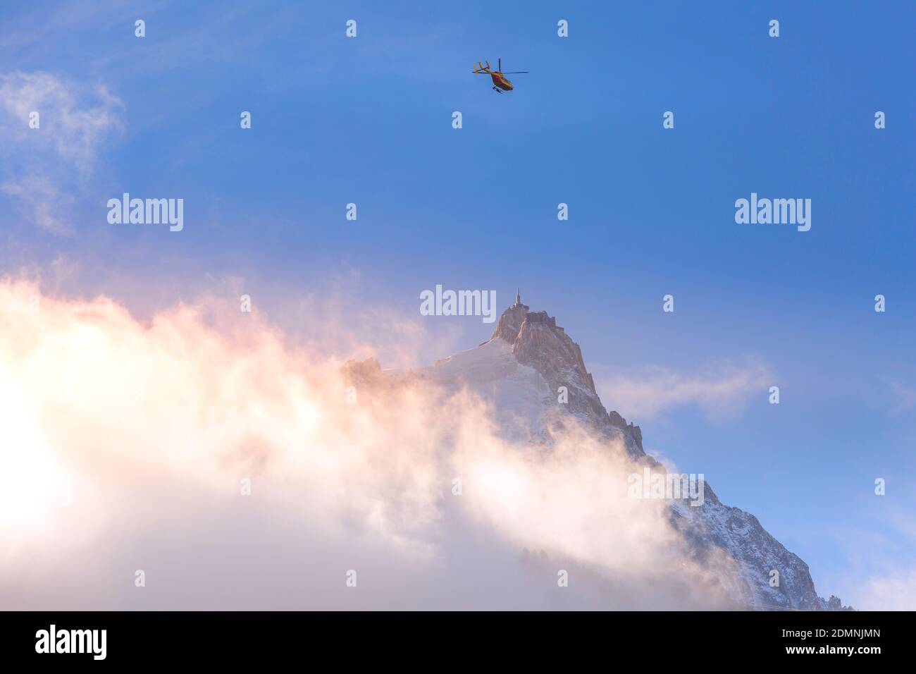 Pointe de l'aiguille du midi entre les nuages, montagne dans le massif du Mont blanc dans les Alpes françaises et hélicoptère, Chamonix, France Banque D'Images