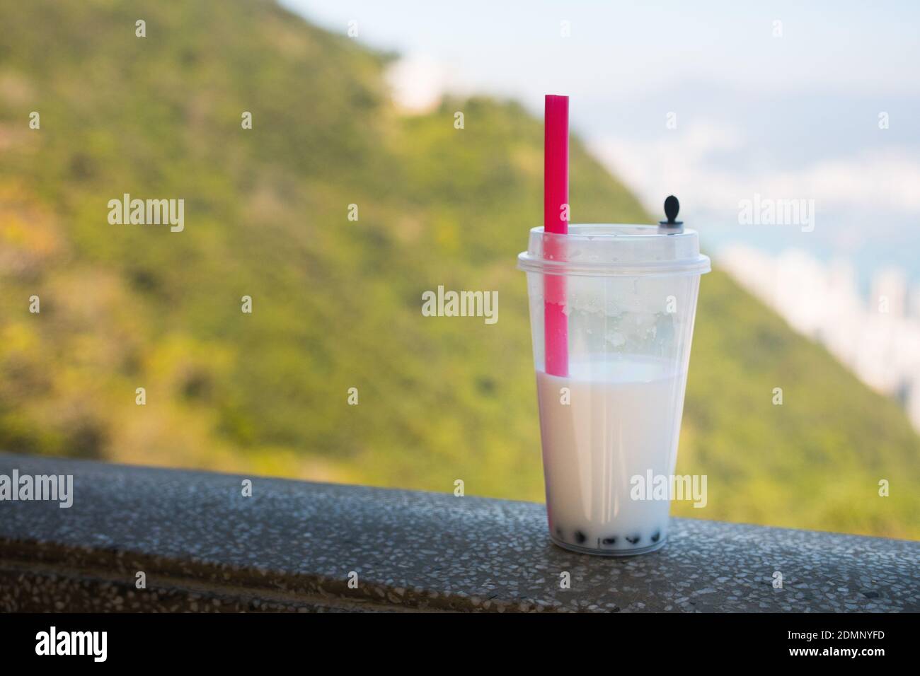 Thé moussant (lait de coco et perles) dans une tasse en plastique avec une paille en plastique. Non écologique. Prise de vue en extérieur. Banque D'Images