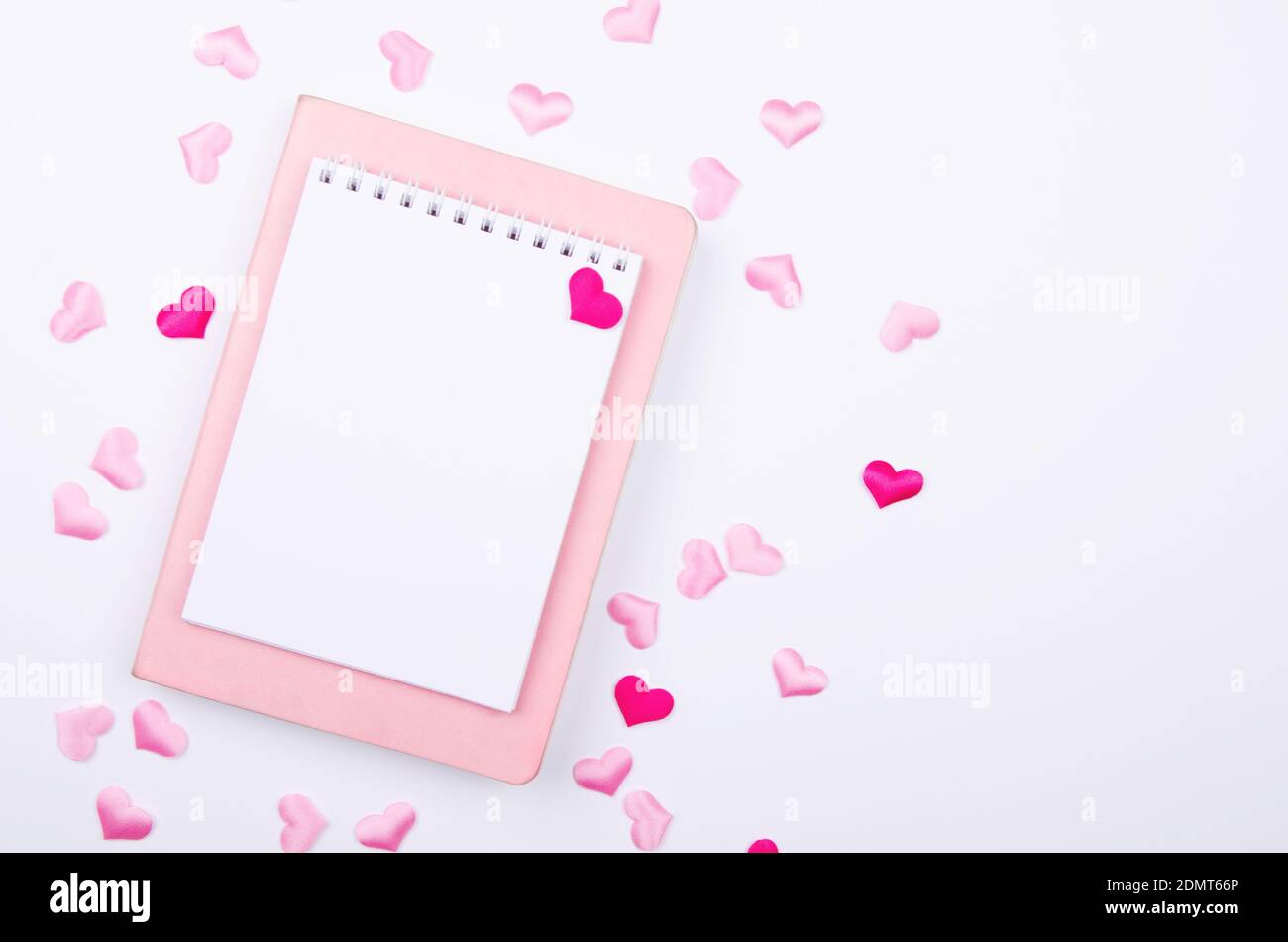 Carnet pour liste de souhaits avec coeurs roses sur fond blanc. Maquette. Banque D'Images