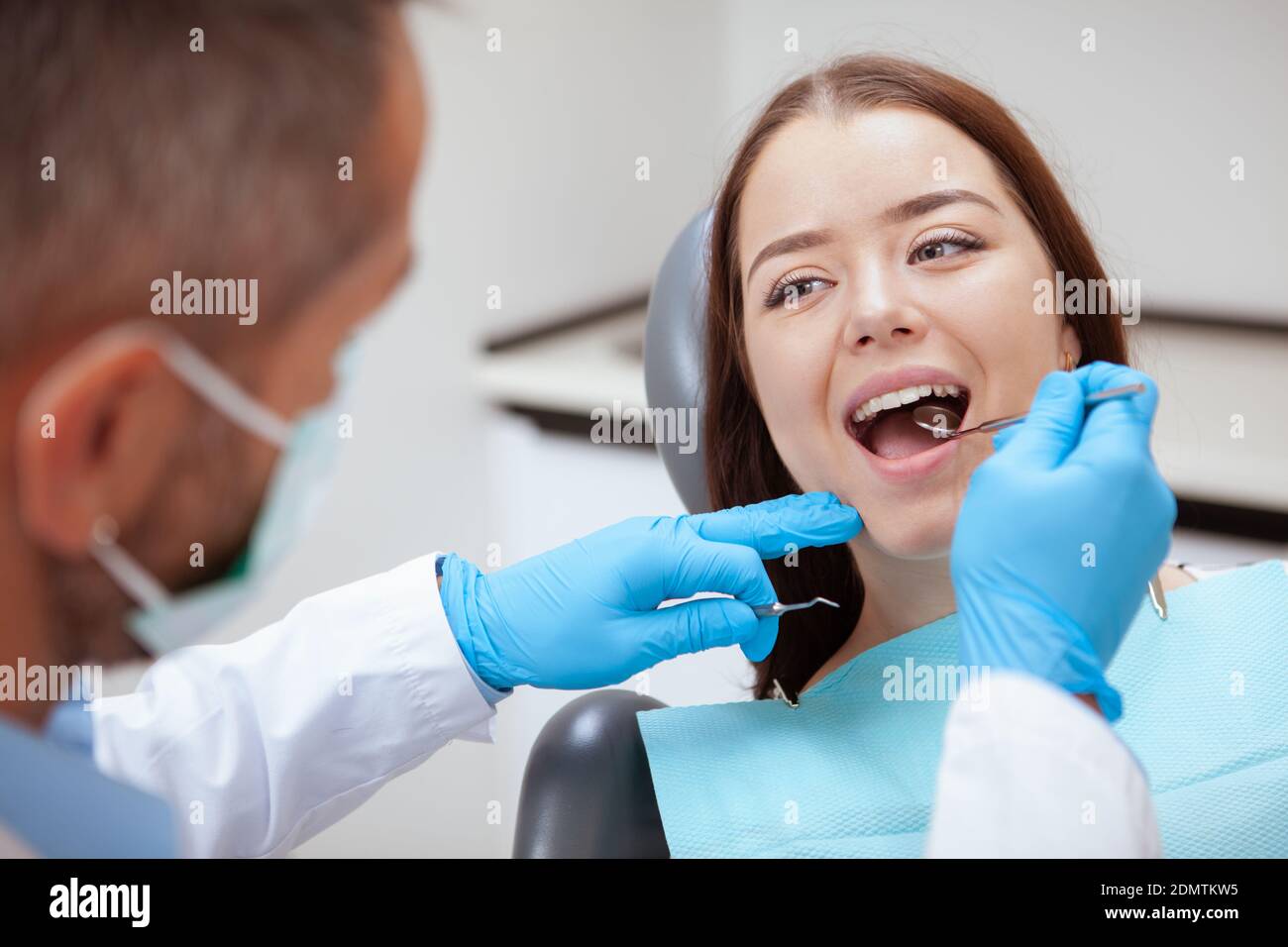 Gros plan d'une jolie jeune femme ayant ses dents examiné par le dentiste Banque D'Images