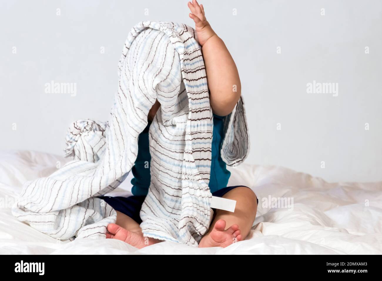 Un bébé mignon couvert et caché sous une couverture Banque D'Images