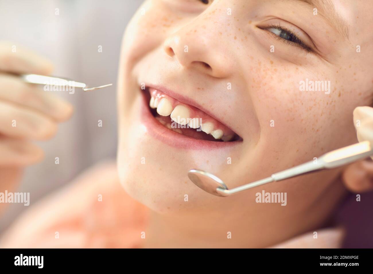Enregistrement de garçon souriant en gros plan dans le cabinet du dentiste. Prévention des caries et traitement dentaire. Banque D'Images