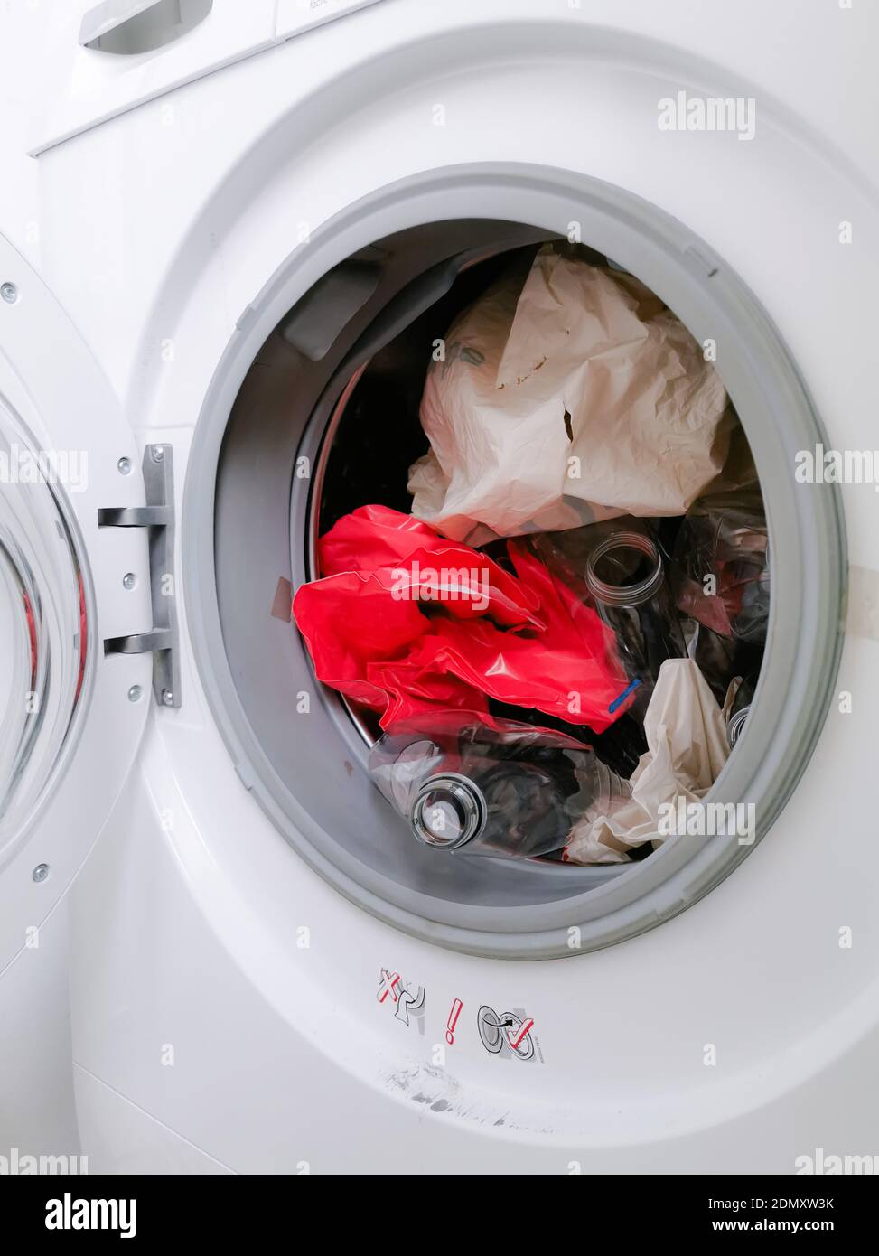 Machine à laver remplie de déchets plastiques représentant les déchets micro-plastiques pollution pendant la lessive Banque D'Images