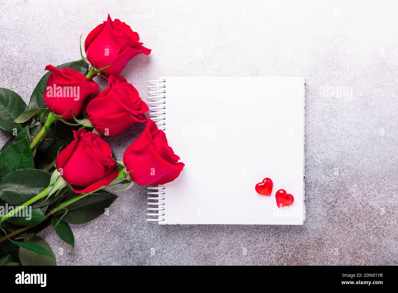 Carnet à croquis, rose rouge et coeurs décoratifs sur fond de pierre espace de copie vue du dessus carte de Saint-Valentin - image Banque D'Images