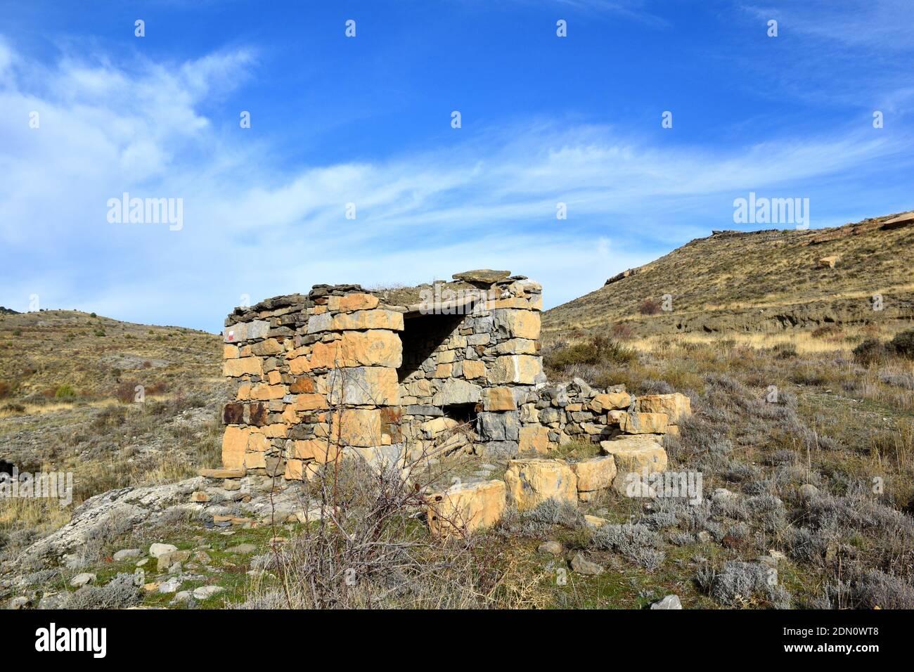 Refuge de bergers en pierre sèche sur la route de campagne. Banque D'Images