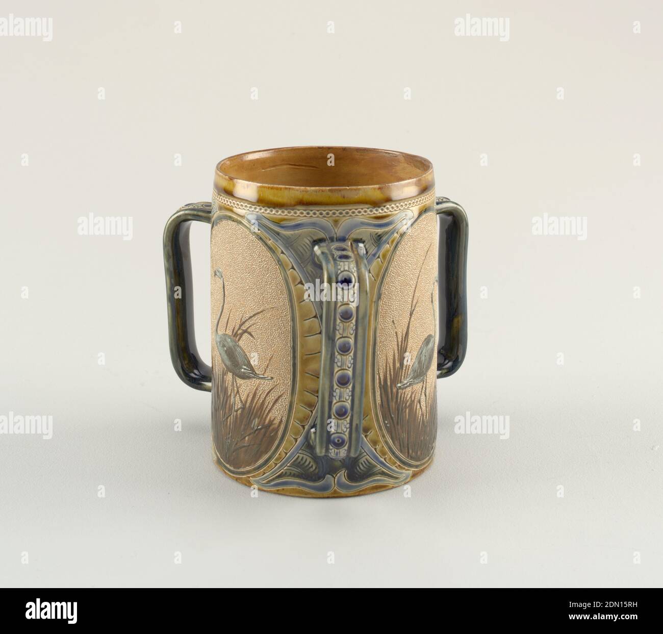 Tankard, Florence E. Barlow, anglais, 1873–1909, Doulton Pottery and Porcelain Company, fondée en 1815, grès moulé, vitrifié et incisé, tankard en grès à trois manche avec ornement glacé et incisé dans les tons de bleu et d'olive encadre trois ovales. Dans chaque ovale, un flamants roses bleu est modelé en relief contre un sol à crépi, un buff léger, chaque flamants roses est en herbe brune., Londres, Angleterre, 1884, céramique, Arts décoratifs, Tankard Banque D'Images