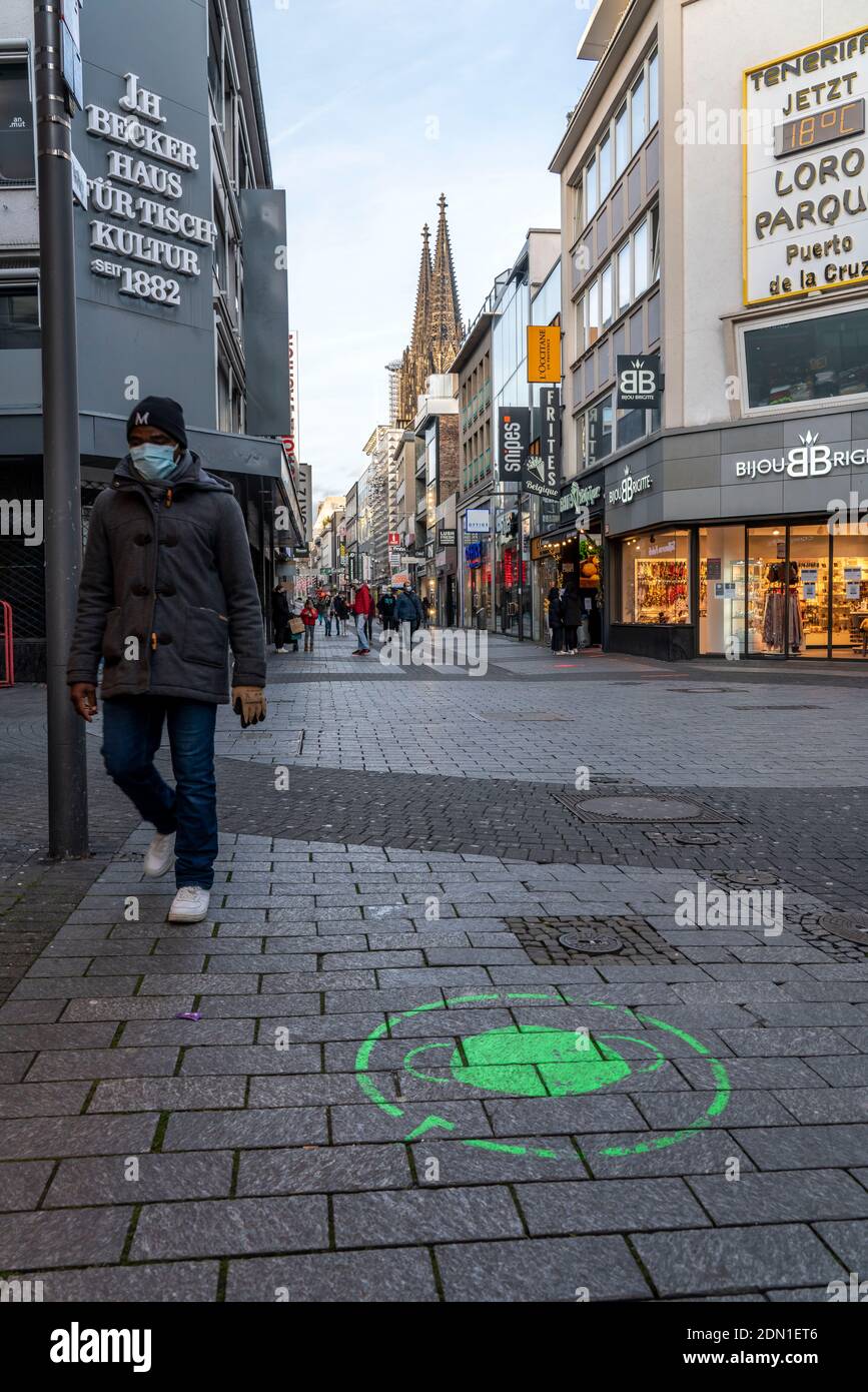 Le premier jour de l'écluse de Noël dans la crise de Corona, rue commerçante vide, magasins fermés, à peine tous les passants, logo sur le sol, avis sur Banque D'Images