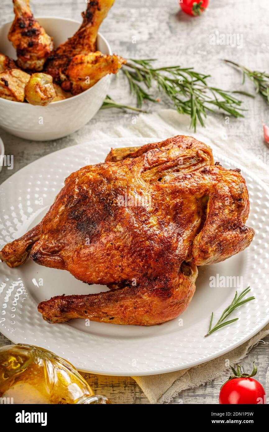 Tabaka de poulet rôti grillé dans une assiette blanche sur table en béton avec des wegetables et des épices Banque D'Images