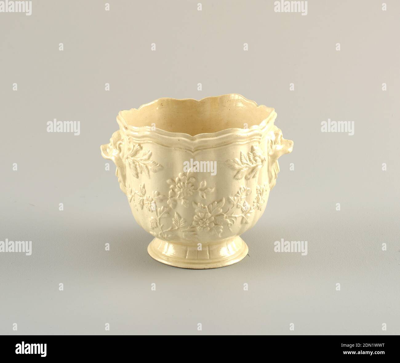 Cachepot avec poignées motif fleur et masque animal, foi, sur le pied de propagation un corps inversé en forme de cloche, en forme de gadrooné avec un bord à six lobes. Côtés décorés de branches à fleurs de relief. Deux masques pour animaux en forme de poignées. Argile à buff légère avec glaçure transparente., Pont-aux-Choux ou Creil, France, ca. 1765, céramique, arts décoratifs, cachepot, cachepot Banque D'Images