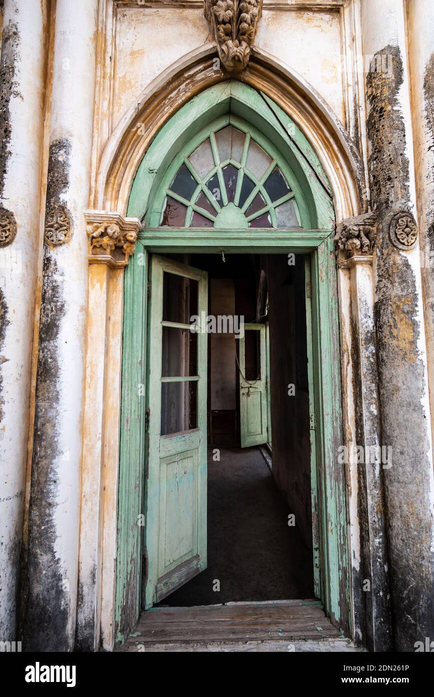 Jamnagar, Gujarat, Inde - décembre 2018 : une ancienne porte en forme d'arche élégante avec portes en bois ouvertes à l'intérieur de l'ancienne mosquée de la tour Mandvi. Banque D'Images