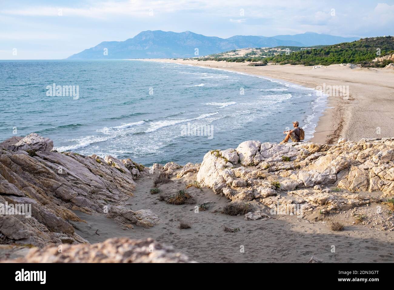 Plage de Patara, Turquie du Sud. Homme assis sur le rocher. Banque D'Images