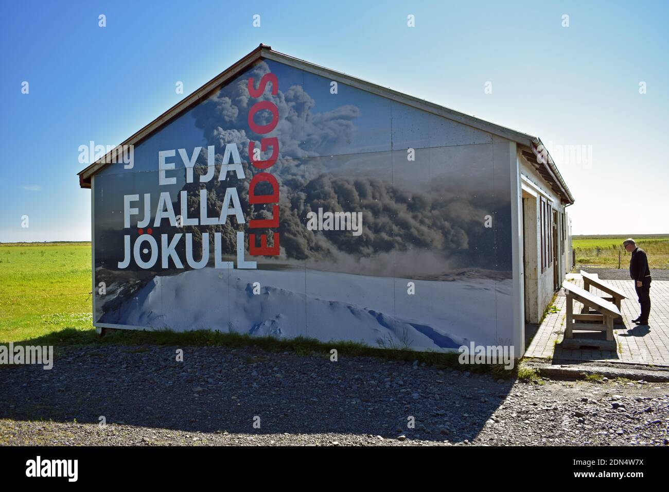 Un petit musée familial consacré à l'éruption du volcan Eyjafjallajokull en 2010. Un homme lit un panneau d'interprétation à l'extérieur du bâtiment. Banque D'Images