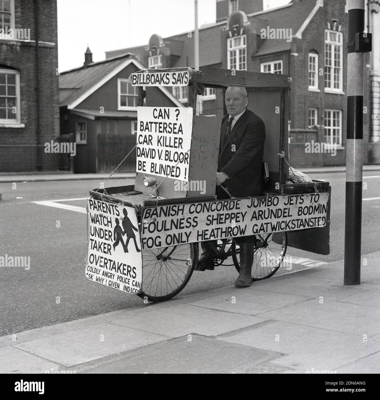 1960s, un militant historique, zélé et excentrique de la sécurité routière, l'ancien commandant de la marine Bill Boaks assis sur son célèbre vélo déocré avec des pancartes de protestation, à côté d'une route très fréquentée dans le sud de Londres, en Angleterre. ROYAUME-UNI. Le commandant Bill Boakes DSC héros naval et cycliste - une inspiration pour hurler Lord Sutch fondateur du parti officiel Monster Raving Loony - a tenu des élections parlementaires comme candidat pendant 30 ans tout d'abord sur un train, Bateaux et avions plate-forme et plus tard sur la sécurité routière campagne comme un monarchiste démocratique de sécurité publique blanc résident. Banque D'Images