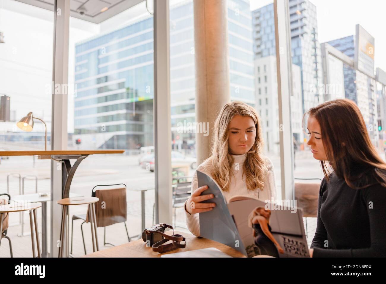 Jeunes professionnels Blogger discutant de la publication dans Cafe Banque D'Images