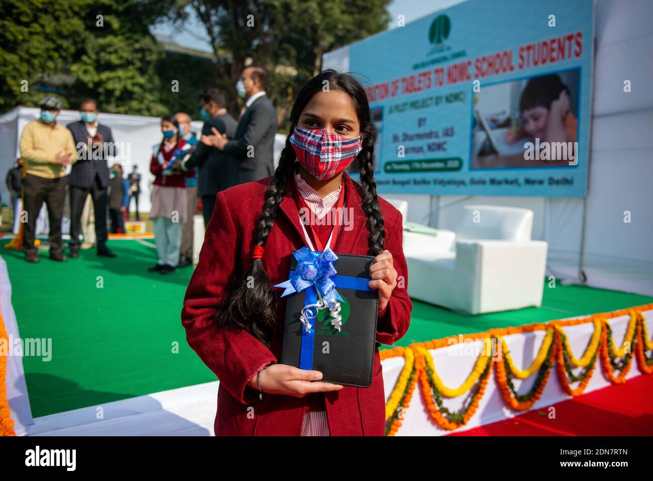 Un étudiant posant avec une tablette pendant la cérémonie de distribution.le Conseil municipal de New Delhi (NDMC) a lancé un projet pilote pour fournir des tablettes gratuites aux étudiants afin de garantir l'apprentissage en ligne pour les classes importantes et cruciales du monde académique pendant la pandémie du coronavirus. La présidente du NDMC Shri Dharmendra a lancé ce projet pilote à Gole Market. Banque D'Images