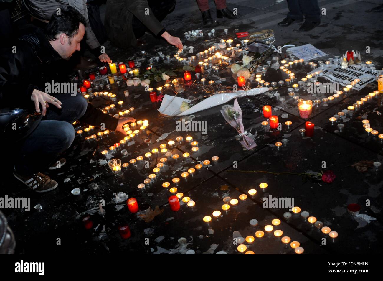 Les gens allument des bougies lors d'un rassemblement sur la place de la République (place de la République) à Paris le 8 janvier 2015, Le deuxième jour d'un hommage aux douze personnes tuées la veille dans une attaque de deux hommes armés sur les bureaux du journal satirique français Charlie Hebdo. Une énorme chasse à l'homme pour deux frères suspectés de massacrer 12 personnes dans une attaque islamiste à une hebdomadaire satirique française mise à zéro dans une ville du nord après la découverte de l'une des voitures d'escapade. Alors que des milliers de policiers resserrés leur filet, le pays marquait une rare journée nationale de deuil pour le bain de sang de mercredi Banque D'Images