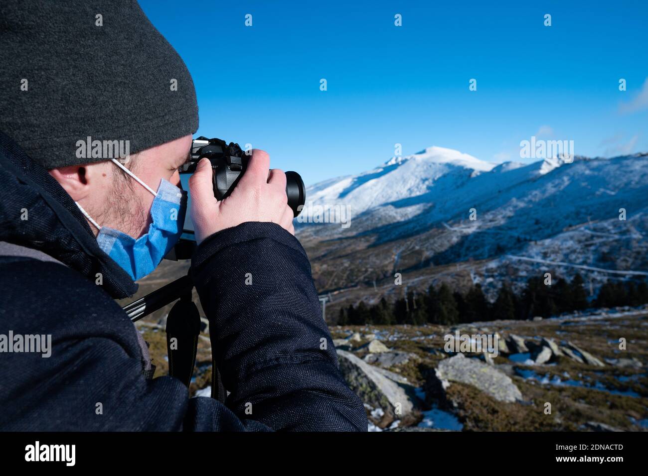 Homme dans la montagne photographiant la montagne couverte de neige Banque D'Images