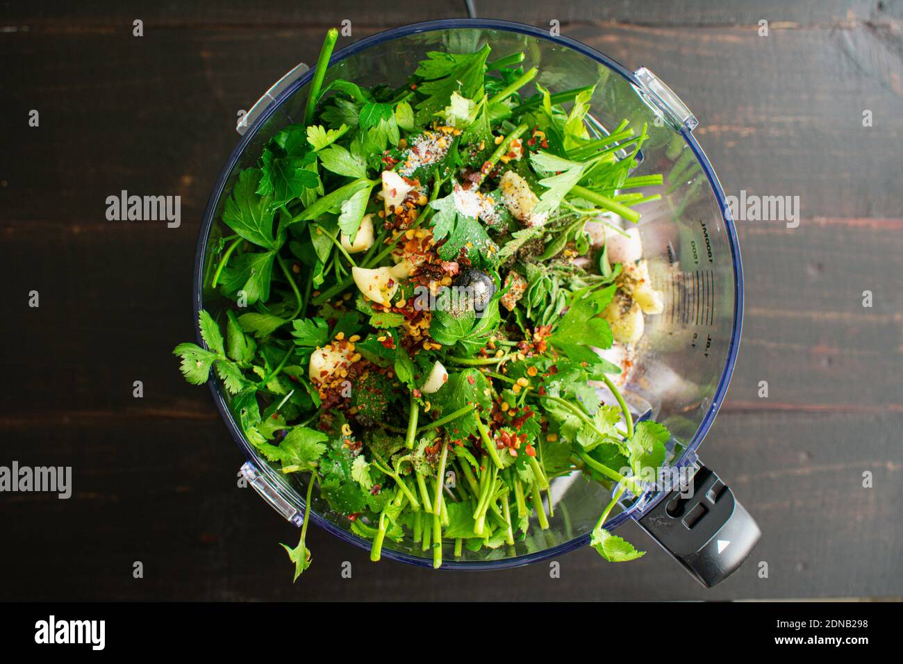 Ingrédients de chimichurri dans un robot ménager : persil, coriandre, ail et autres ingrédients de chimichurri dans un bol de robot ménager Banque D'Images