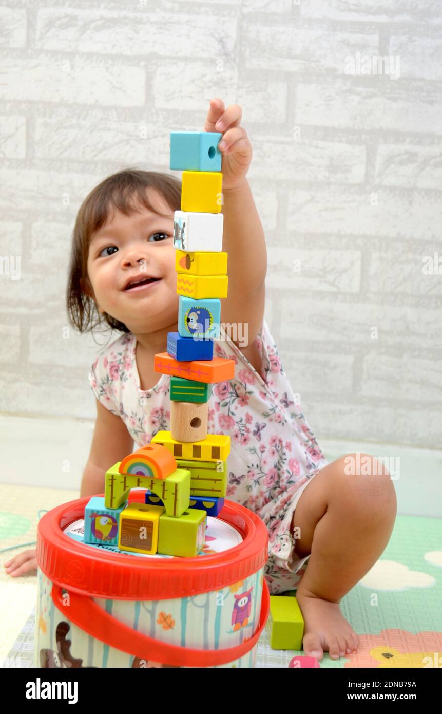 Petite fille, 2 ans, jouant de bloc de bois coloré Banque D'Images