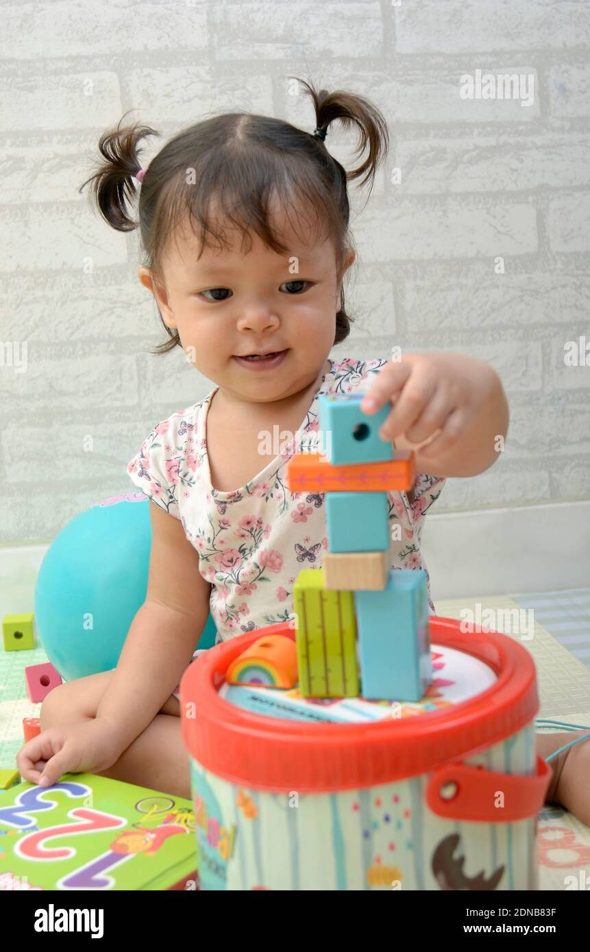 Petite fille, 2 ans, jouant de bloc de bois coloré Banque D'Images