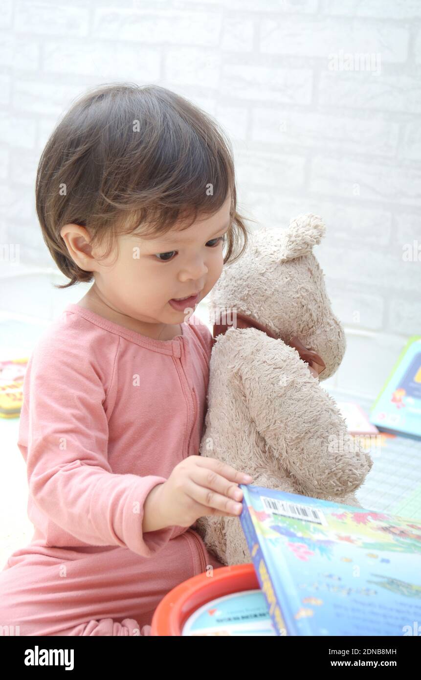 2 ans, todller, fille de bébé asiatique, jouant avec son livre.Reading un livre. Banque D'Images