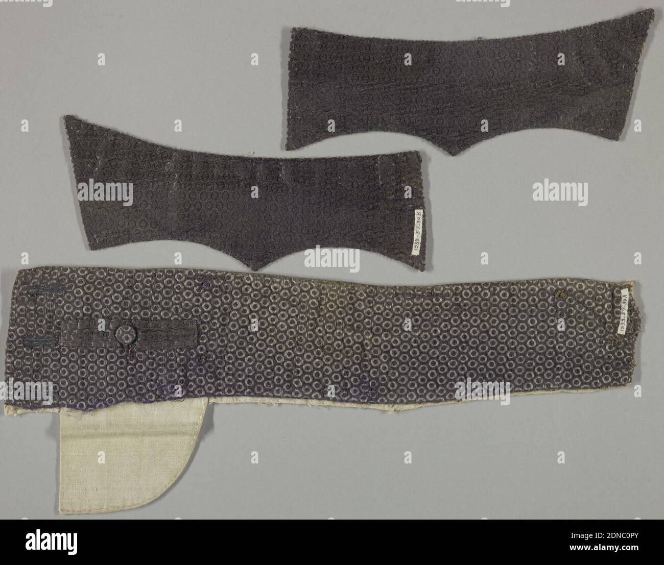 Fragments, Medium: Silk technique: Uncut voided supplémentaire Warp pile (velours) avec trame supplémentaire, deux rabats de poche de manteau ou de gilet (composants b/c) sont doublés de sergé de soie ivoire. La taille supérieure gauche des culottes (composante a) est doublée d'un tissu Uni en lin. Le velours violet non coupé a des flotteurs de fond dans une trame de soie pourpre secondaire. Le velours violet non coupé forme une petite conception sur toute la surface des hexagones, chacun entourant un point rond. La taille est dotée d'une poche avec fermeture à boutons et de trois boutonnières sur le bord gauche., France, 1750–1800, textiles tissés, fragments Banque D'Images