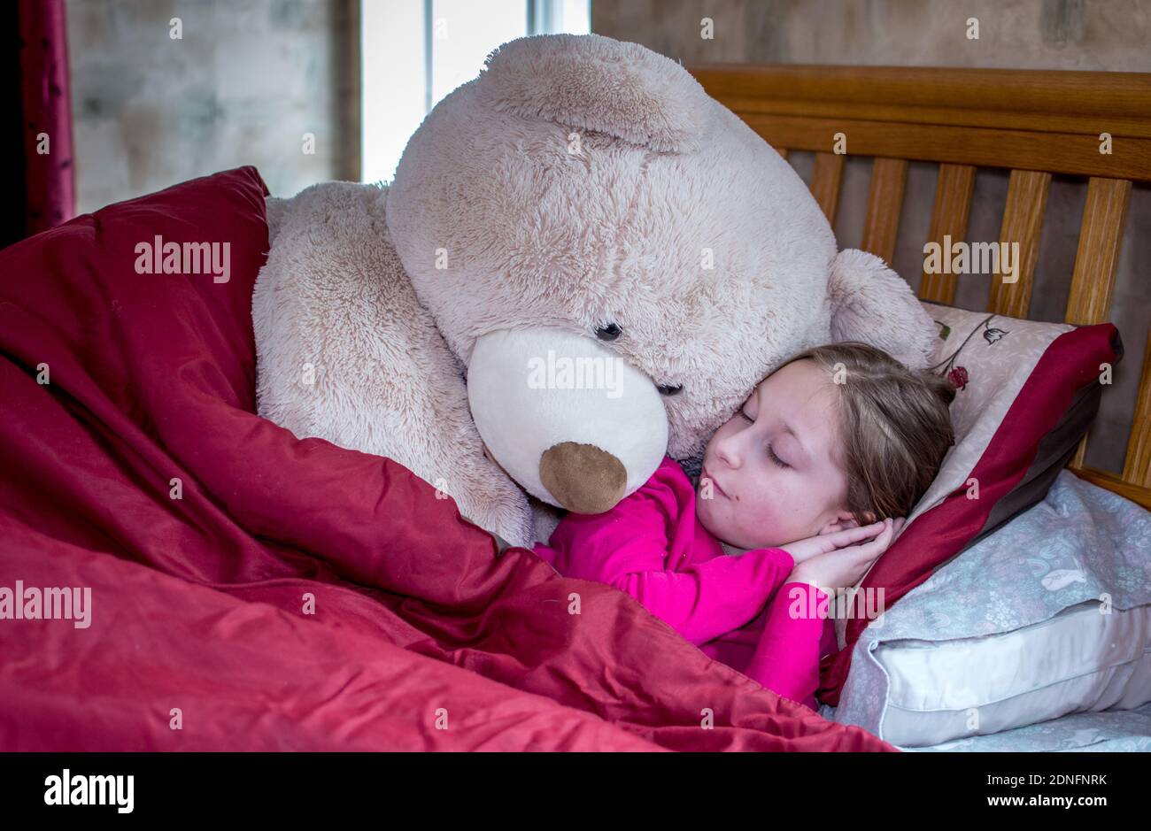 Jolie Petite Fille Au Lit Avec Un Ours En Peluche Geant Quelqu Un Est En Train De Faire De La Plongee Photo Stock Alamy