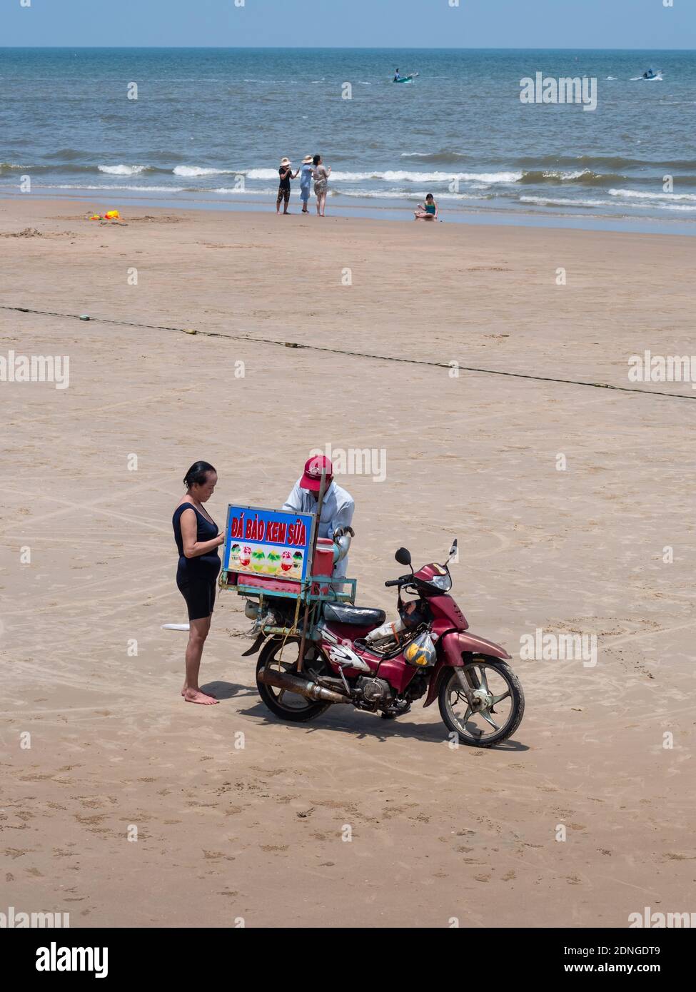 Vendeur de plage à la plage de Bai Bien à Vung Tau dans la province de Bang Ria-Vung Tau, au Vietnam du Sud, vendant des bonbons de sa moto. Banque D'Images