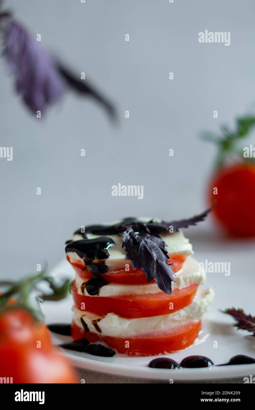 Hors-d'œuvre italien Caprese. Tomates et mozzarella. Avec vinaigre balsamique. Avec basilic foncé Banque D'Images