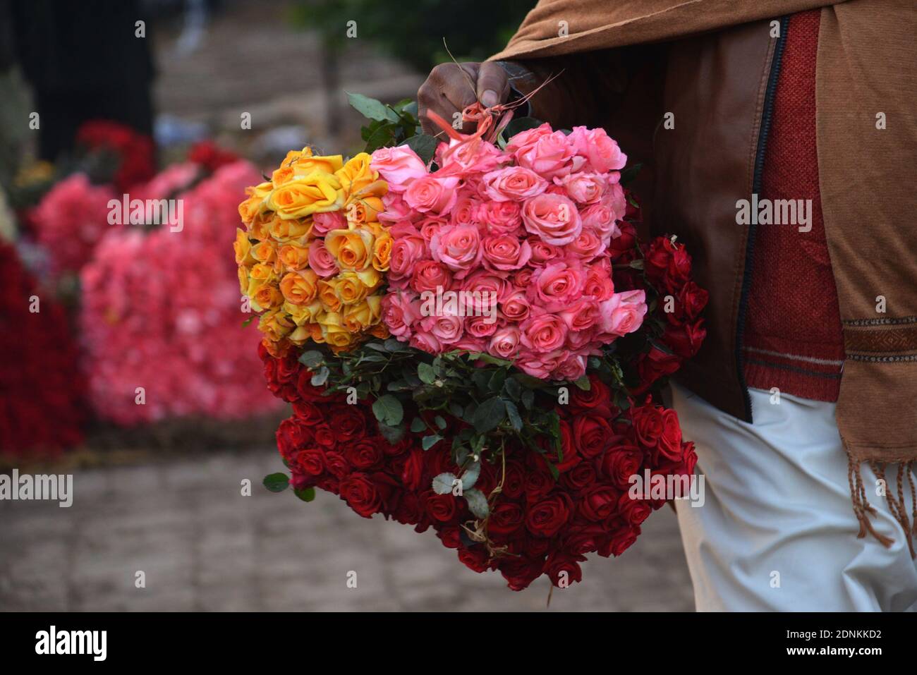 Un Paki Avec Un Bouquet De Rose Les grossistes pakistanais de fleurs présentent des roses et des guirlandes  fraîches pour attirer les clients sur le marché des fleurs (Phool Mandi)  comme les exigences des fleurs élevées pour les célébrations