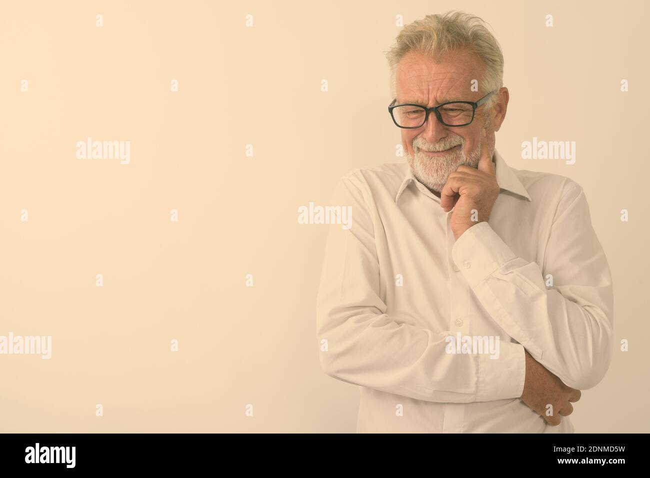 Studio shot of senior triste pensée homme barbu avec des lunettes en pleurant contre fond blanc Banque D'Images