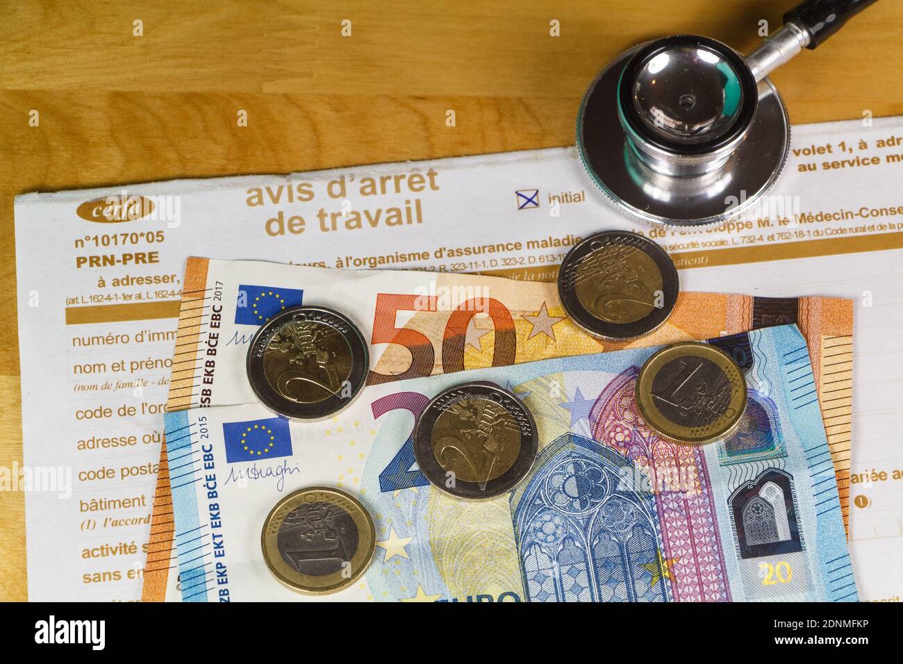 Avis d'arrêt de travail médical en France, stéthoscope noir, billets et pièces en euros Banque D'Images