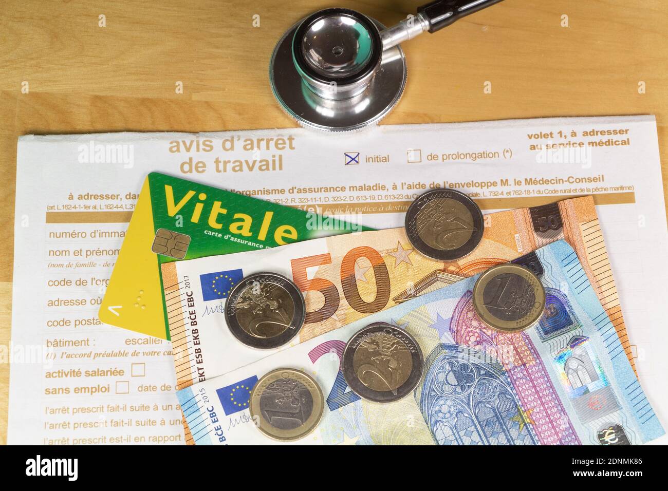 Avis d'arrêt de travail médical écrit en français, carte vitale, stéthoscope noir et argent euro Banque D'Images