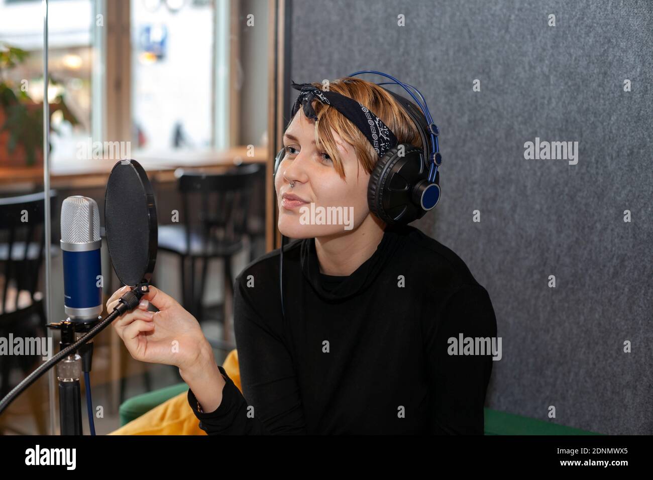 Femme portant un casque et assise à une table avec microphone Banque D'Images