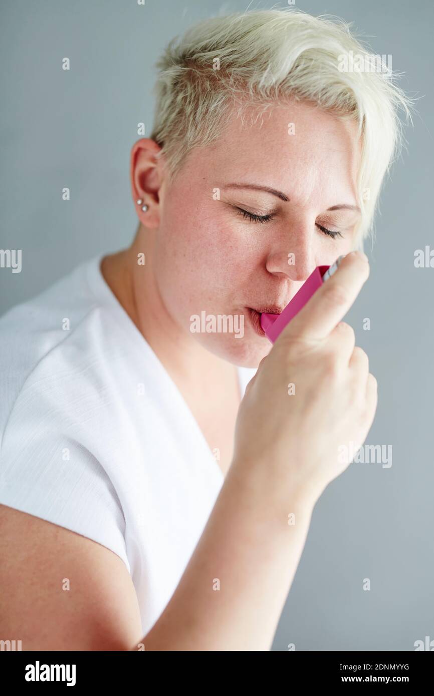 Femme à l'aide d'inhaler Banque D'Images