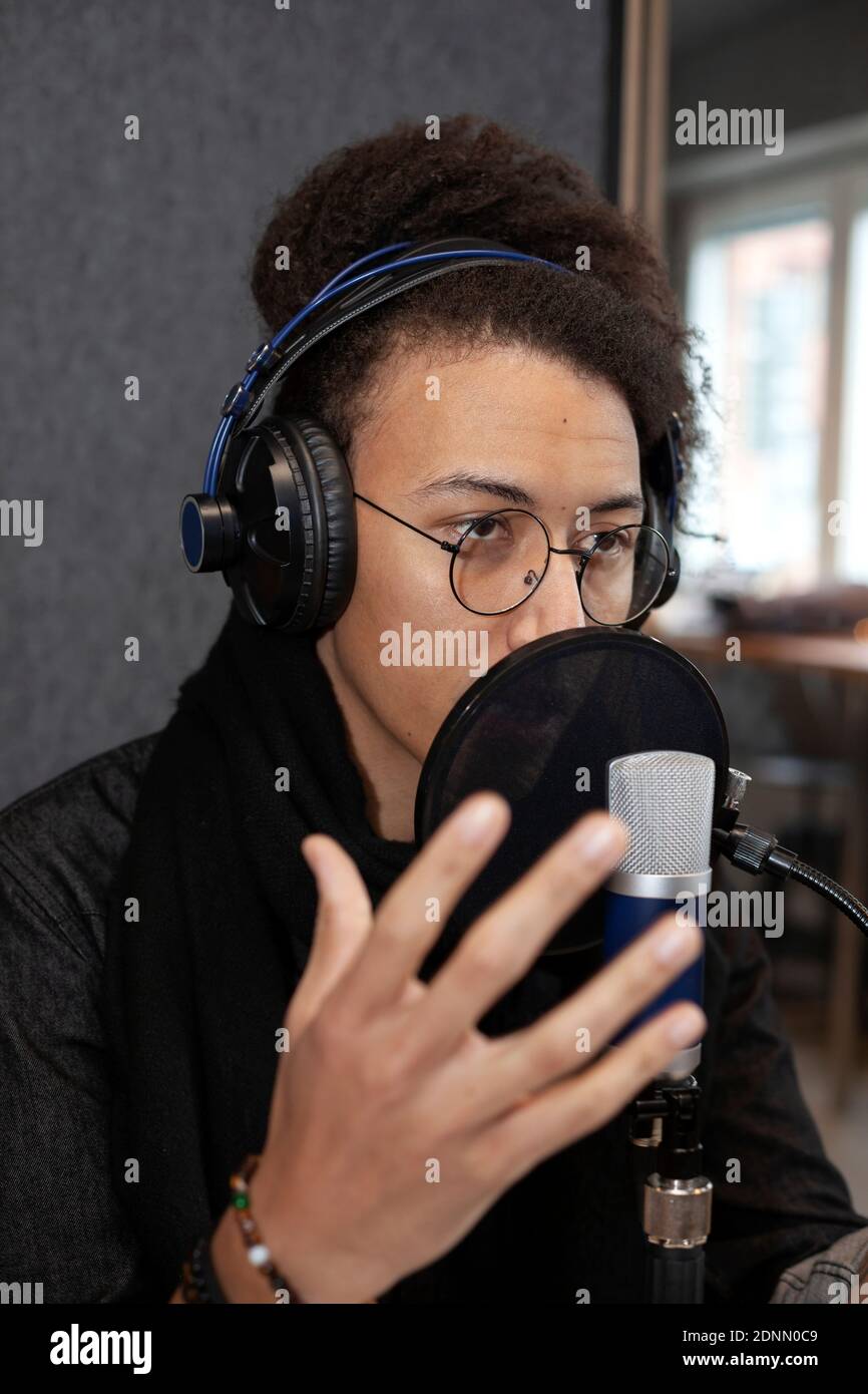 Homme portant un casque et assis à une table avec microphone Banque D'Images