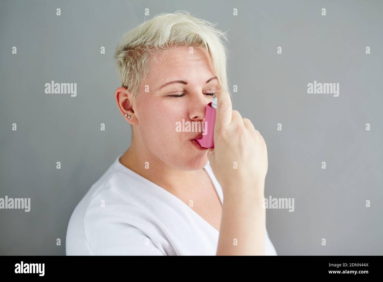 Femme à l'aide d'un inhalateur d'asthme Banque D'Images