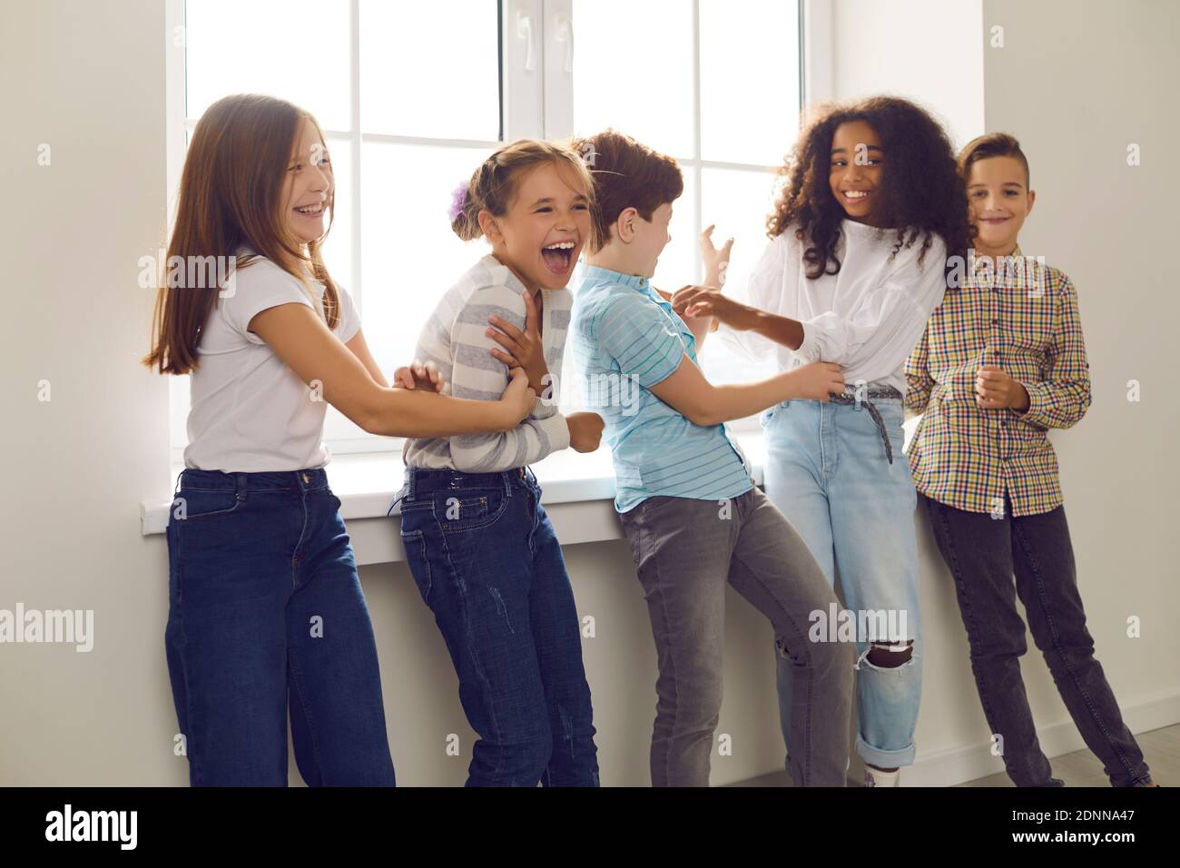 Groupe d'enfants jouant et riant pendant le congé à l'école ou de la fête à la maison Banque D'Images