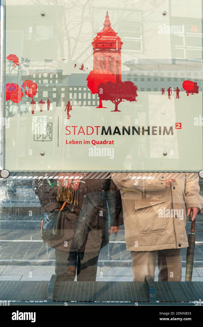 Mannheim, Allemagne. 27 novembre 2011. Arrêt de tramway avec logo de la ville, où les personnes âgées attendent. Banque D'Images