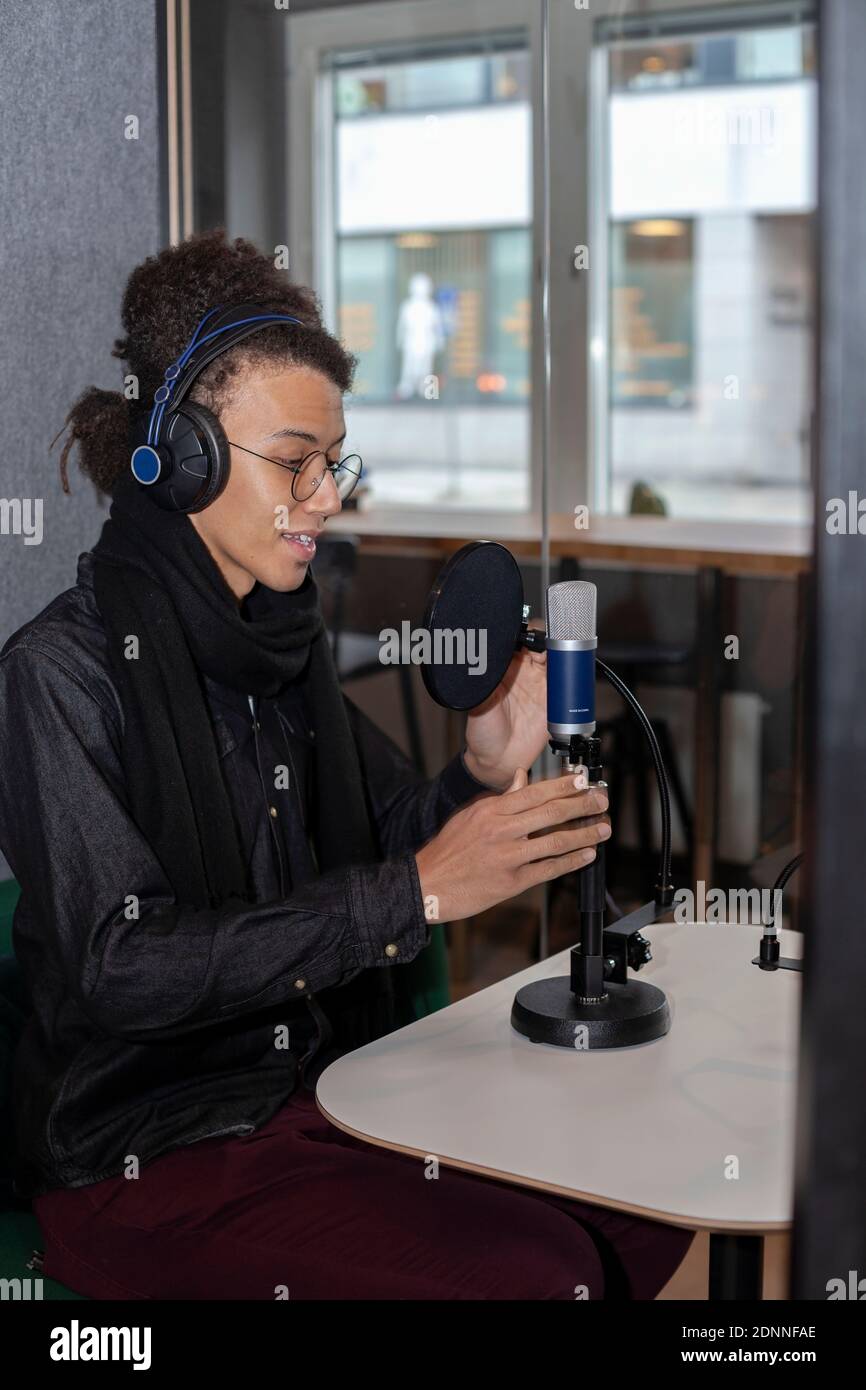 Homme portant un casque et assis à une table avec microphone Banque D'Images