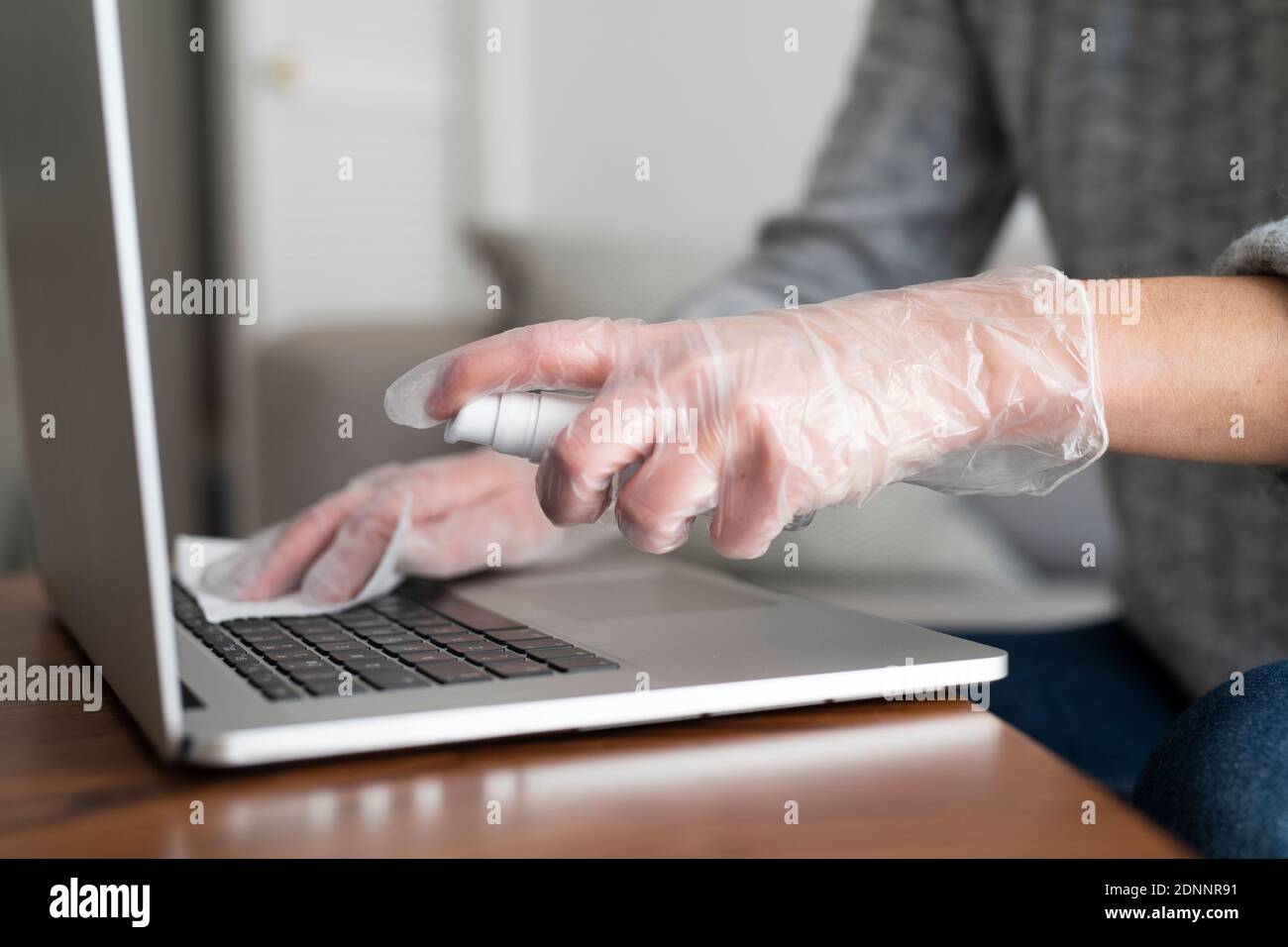 Femme désinfectant ordinateur portable Banque D'Images
