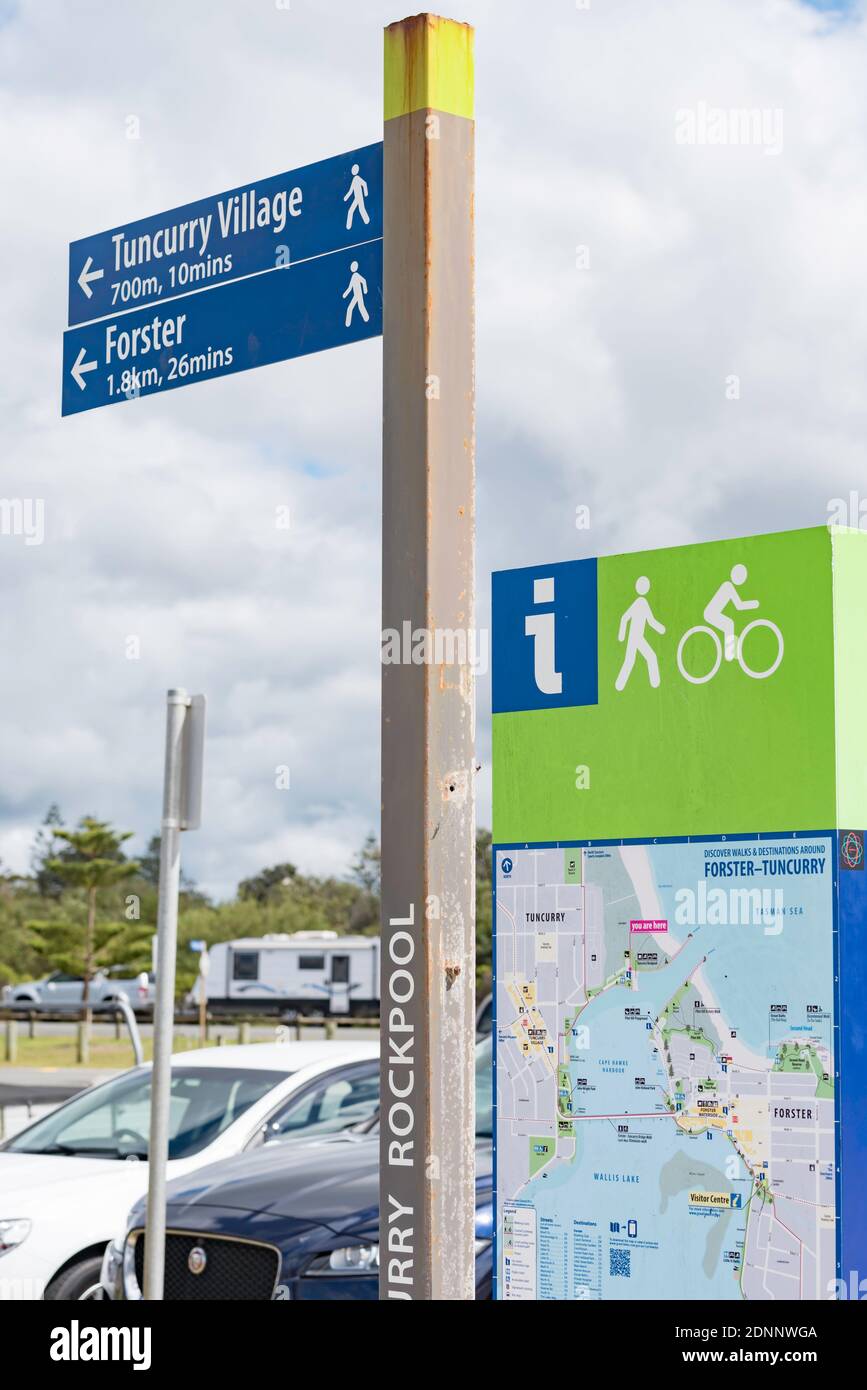 Un panneau de signalisation, un panneau et une carte indiquant la distance et le temps de marche et de vélo vers les sites de Forster Tuncurry, Nouvelle-Galles du Sud, Australie Banque D'Images