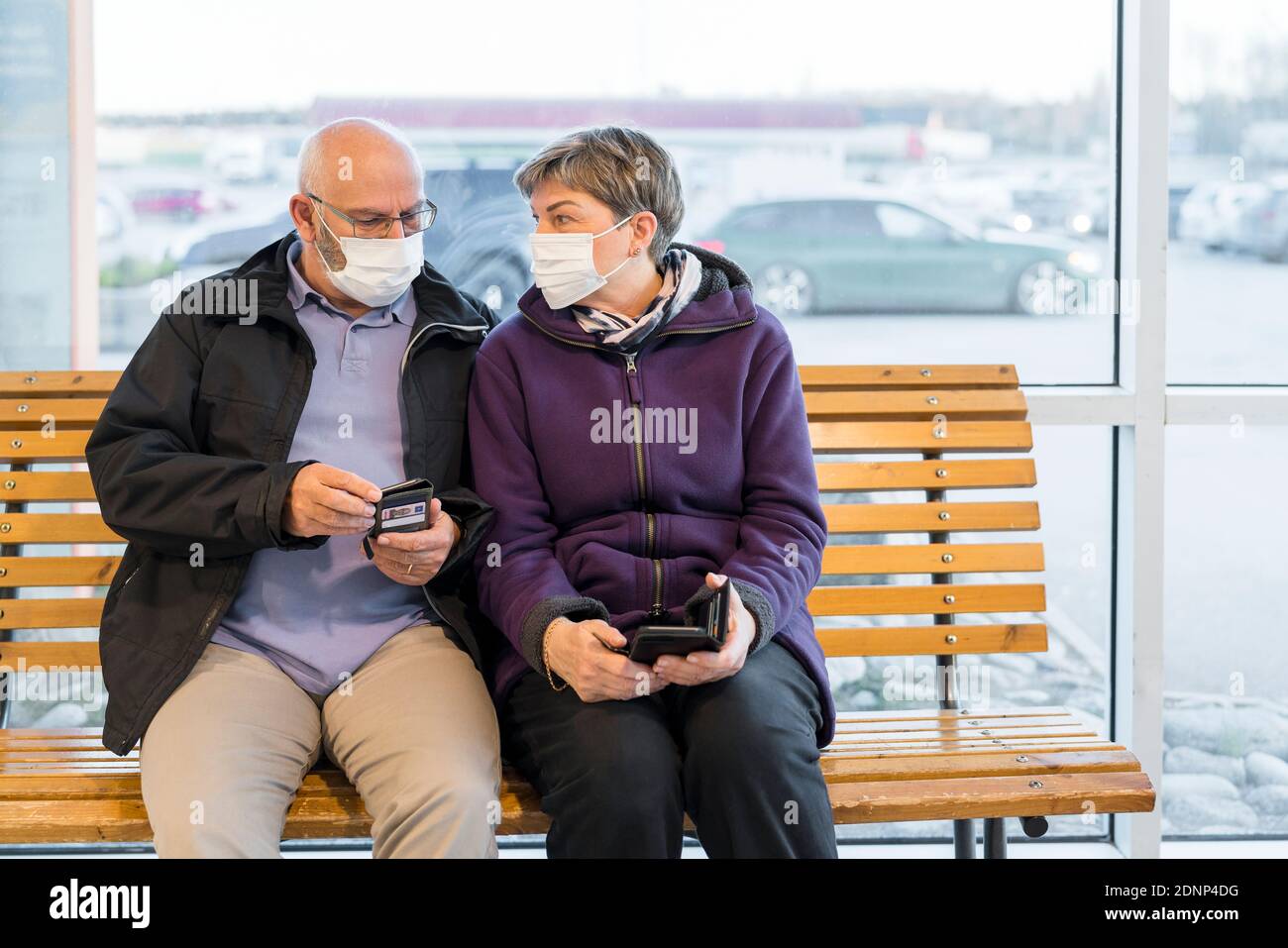 Couple portant un masque de protection assis sur un banc Banque D'Images
