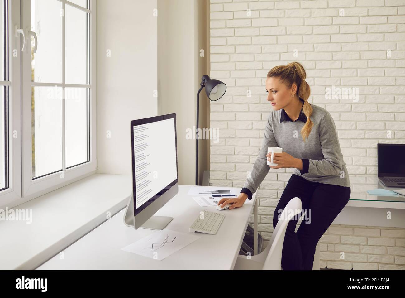 Employé de l'entreprise regardant l'écran de l'ordinateur de bureau et étudiant résultats de la recherche Banque D'Images