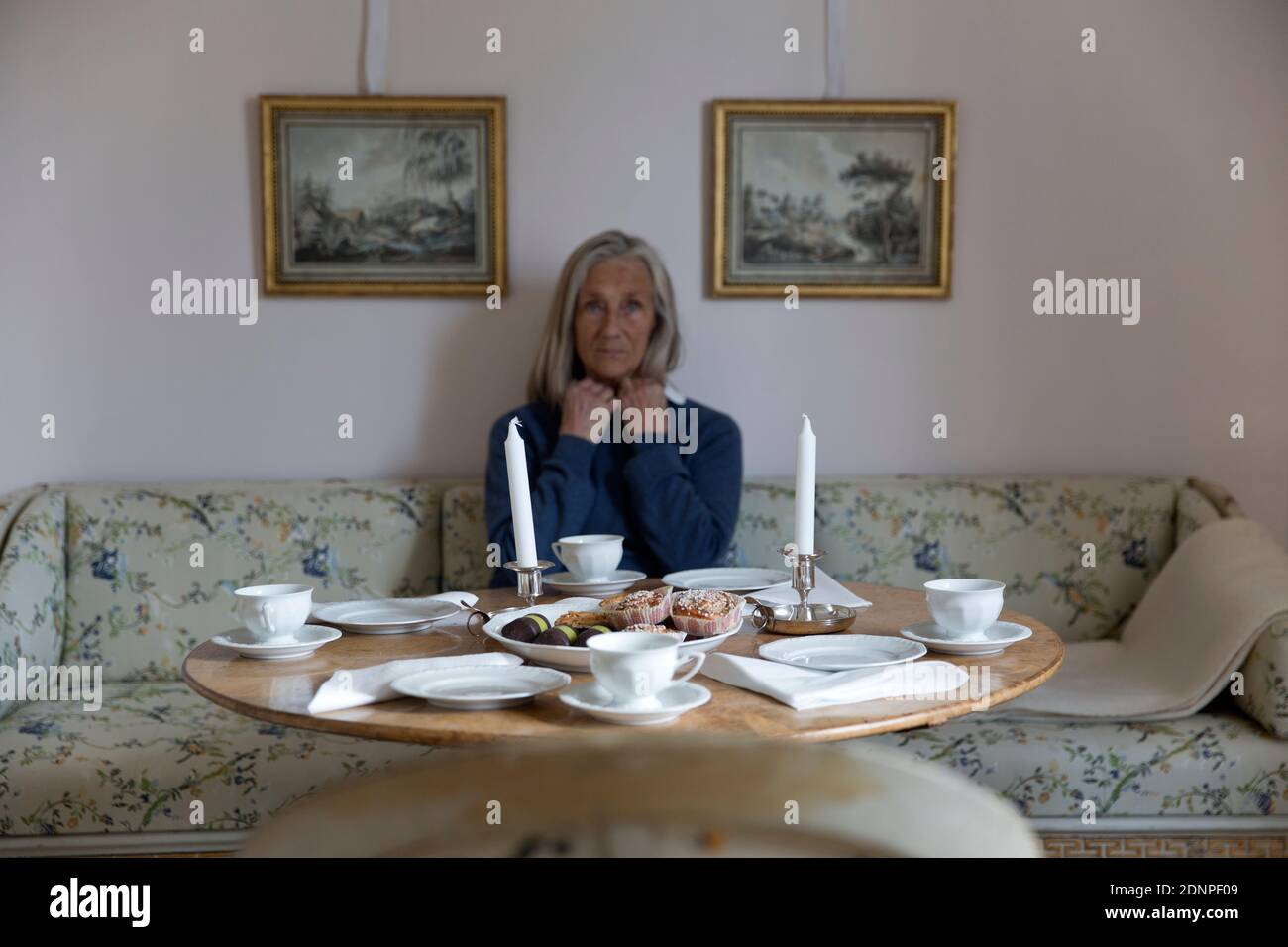 Woman sitting at table Banque D'Images