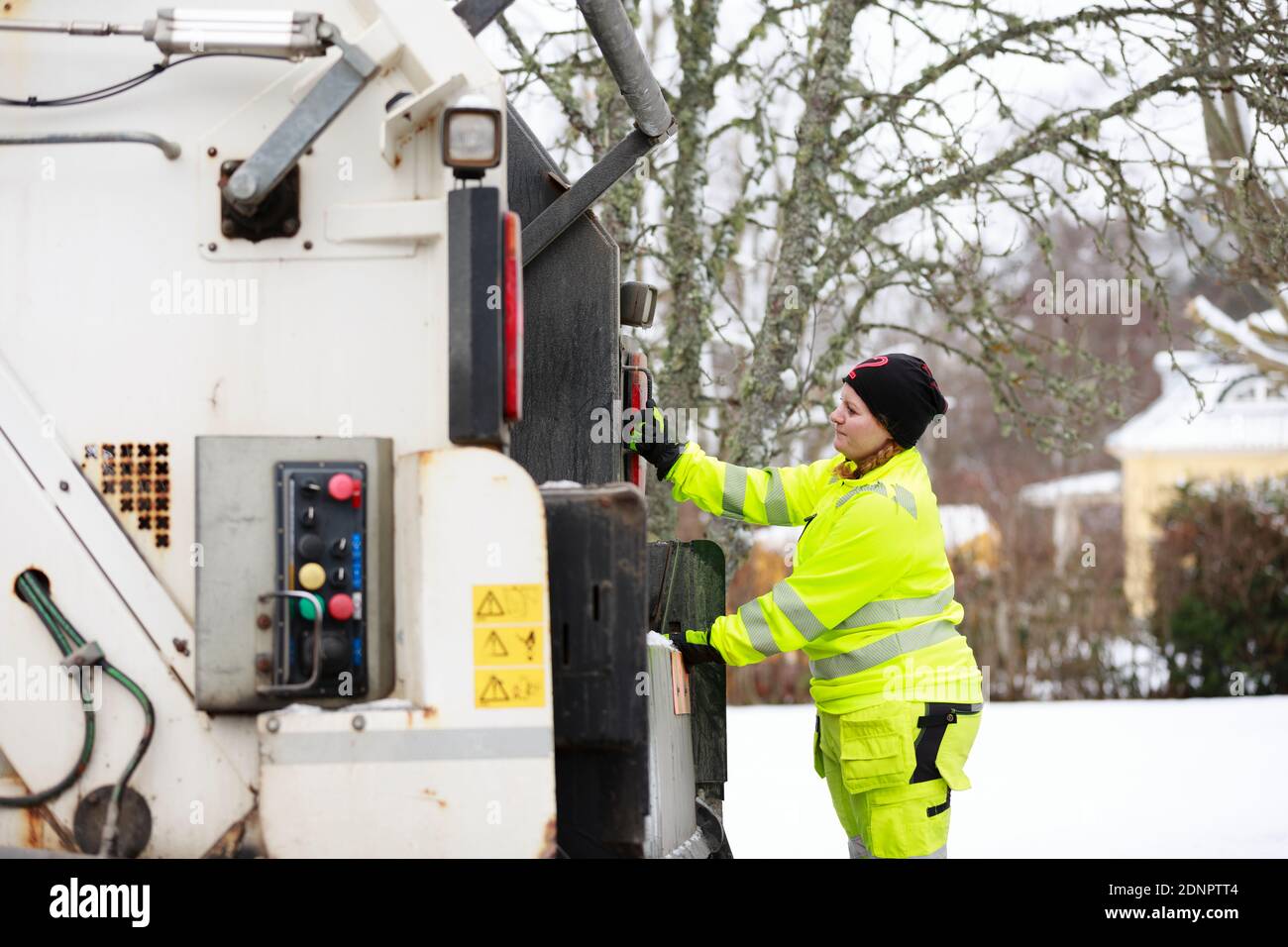 Femme utilisant un camion à ordures Banque D'Images