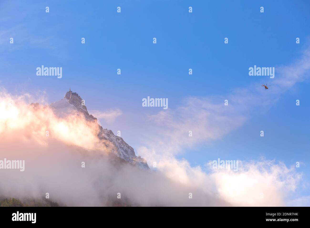 Pointe de l'aiguille du midi entre les nuages, montagne dans le massif du Mont blanc dans les Alpes françaises et hélicoptère, Chamonix, France Banque D'Images