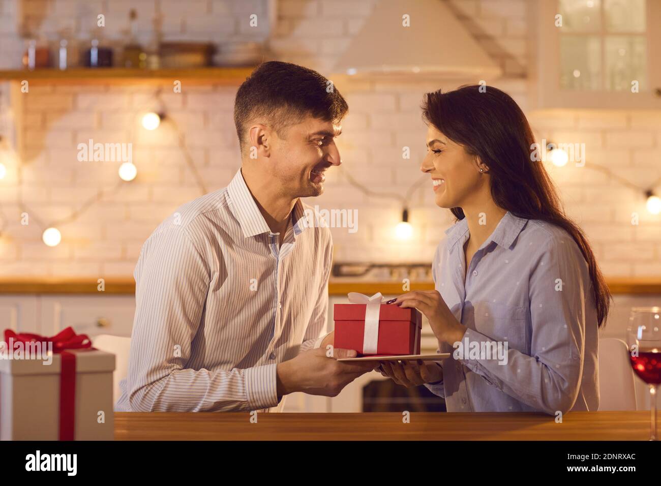 Couple souriant amoureux de donner des cadeaux de vacances les uns aux autres Pendant la fête de la Saint-Valentin Banque D'Images